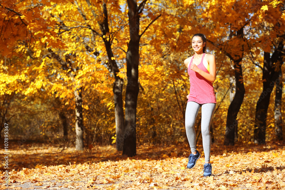 Young beautiful woman jogging in autumn park Young beautiful woman jogging in autumn park