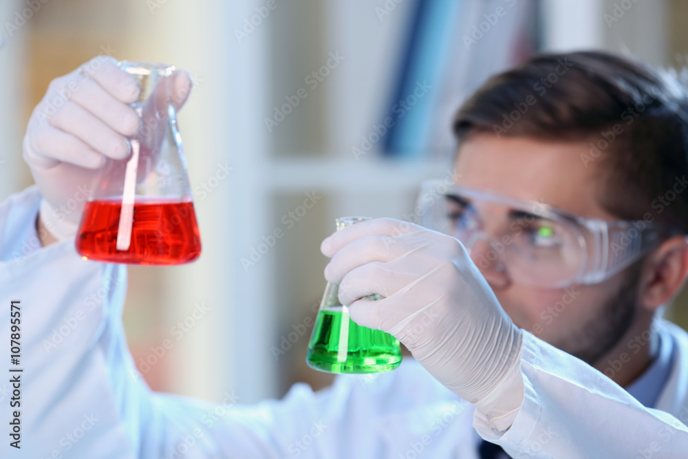 Man in laboratory checking test tubes Man in laboratory checking test tubes