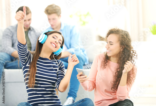 Two teenager girls listenin...