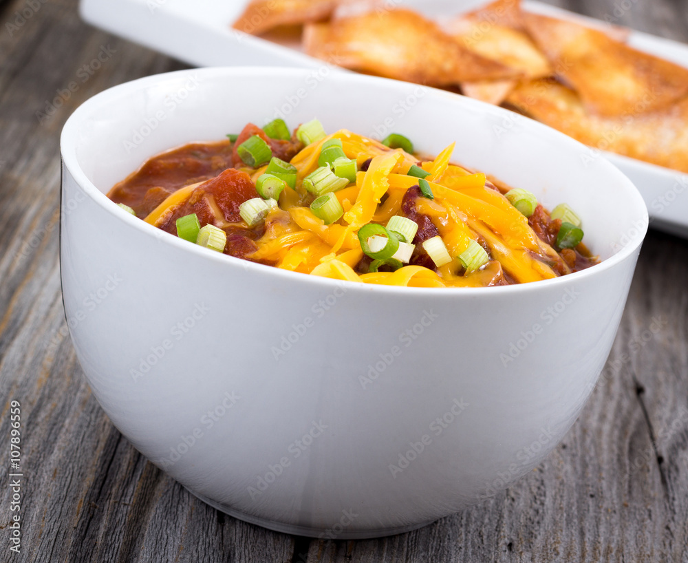 chili con carne bowl over a wooden table chili con carne bowl over a wooden table