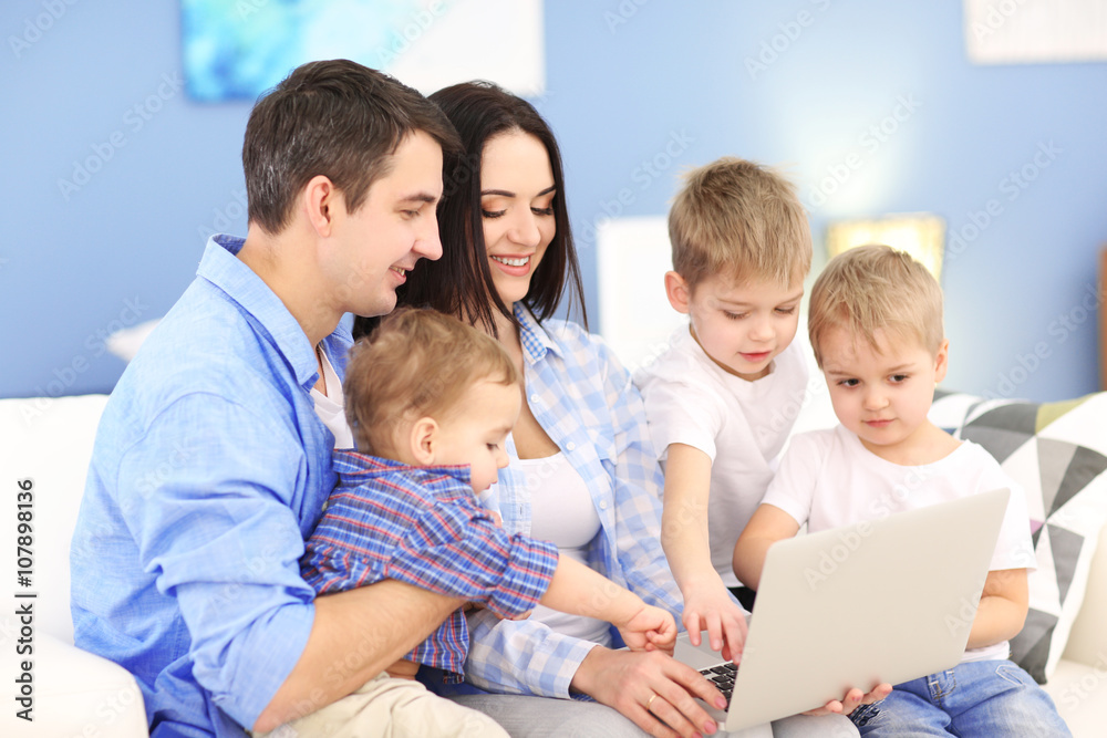 Family concept. Happy family with laptop on sofa in the room Family concept. Happy family with laptop on sofa in the room