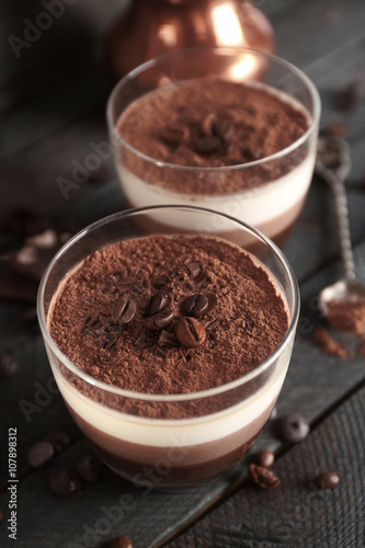 Delicious dessert with chocolate powder and coffee beans in glass