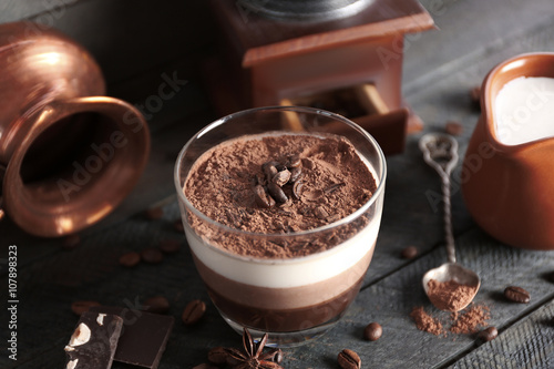 Delicious dessert with chocolate powder and coffee beans in glass