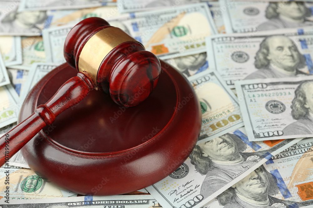 Law gavel on dollars background, closeup