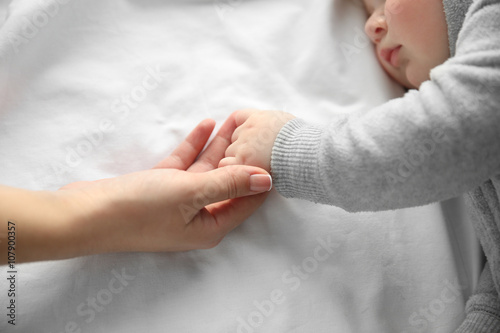 Hands of mother and her lit...