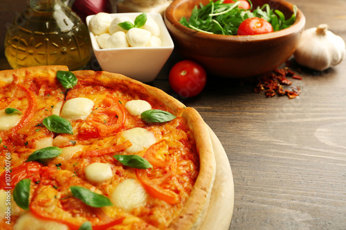 Margherita pizza with tomatoes and Mozzarella on wooden background