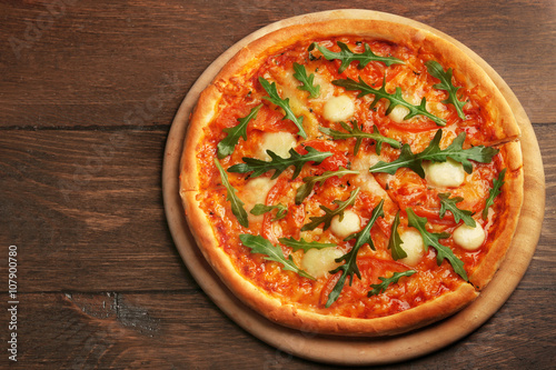 Margherita pizza with arugula on background