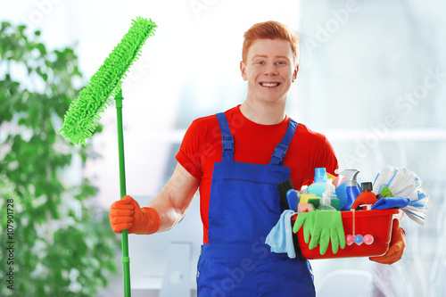 Young janitor holding clean...