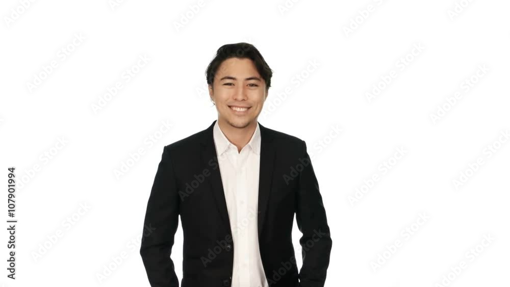 Adult businessman wearing a black suit and white shirt, standing against a white background with a big smile on his face. Video shot in 4K. Adult businessman wearing a black suit and white shirt, standing against a white background with a big smile on his face. Video shot in 4K.