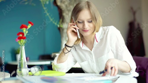 Businesswoman having a businesscall and working on documents
 photo