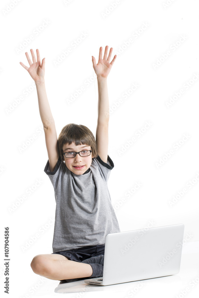 young boy with arms up in the air in grey t-shirt with laptop young boy with arms up in the air in grey t-shirt with laptop