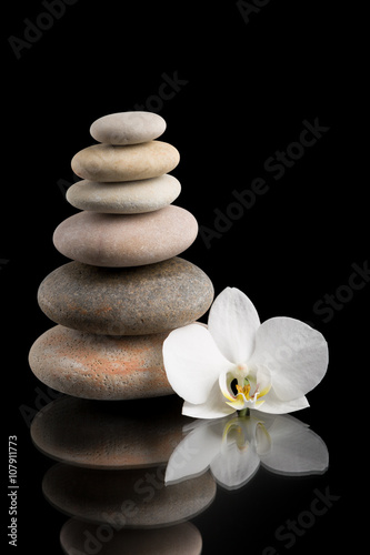 balancing zen stones on black with white flower
