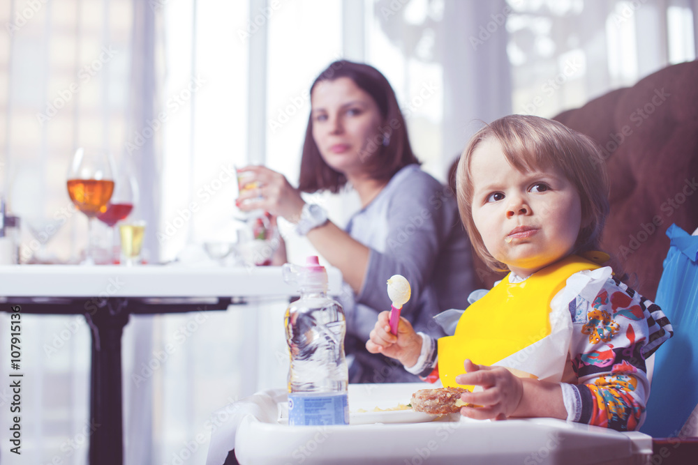 Mother with baby eating in a restaurant.