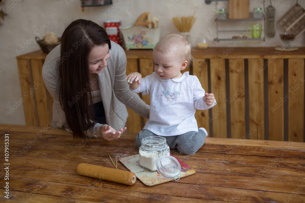 Fototapeta premium mother with her baby daughter in kitchen together cooking, lifes