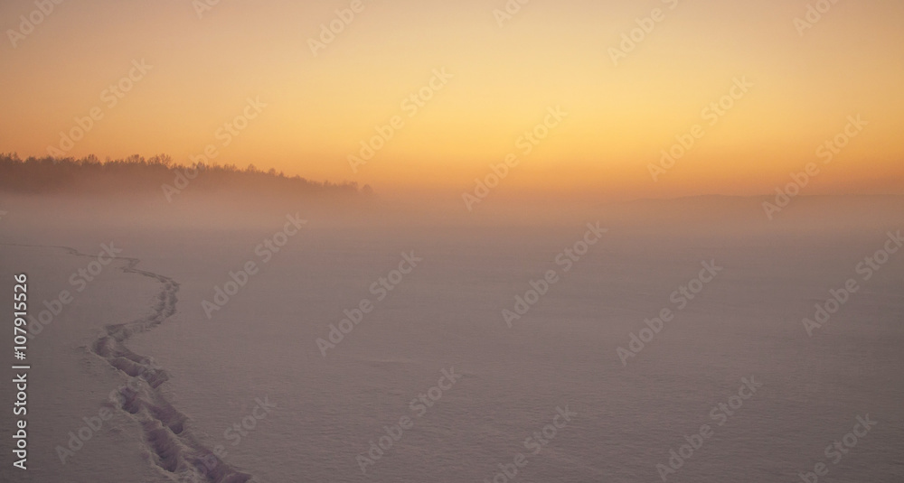 wonderful sunrise, someone's trail, footprints on the snow in the mist wonderful sunrise, someone's trail, footprints on the snow in the mist