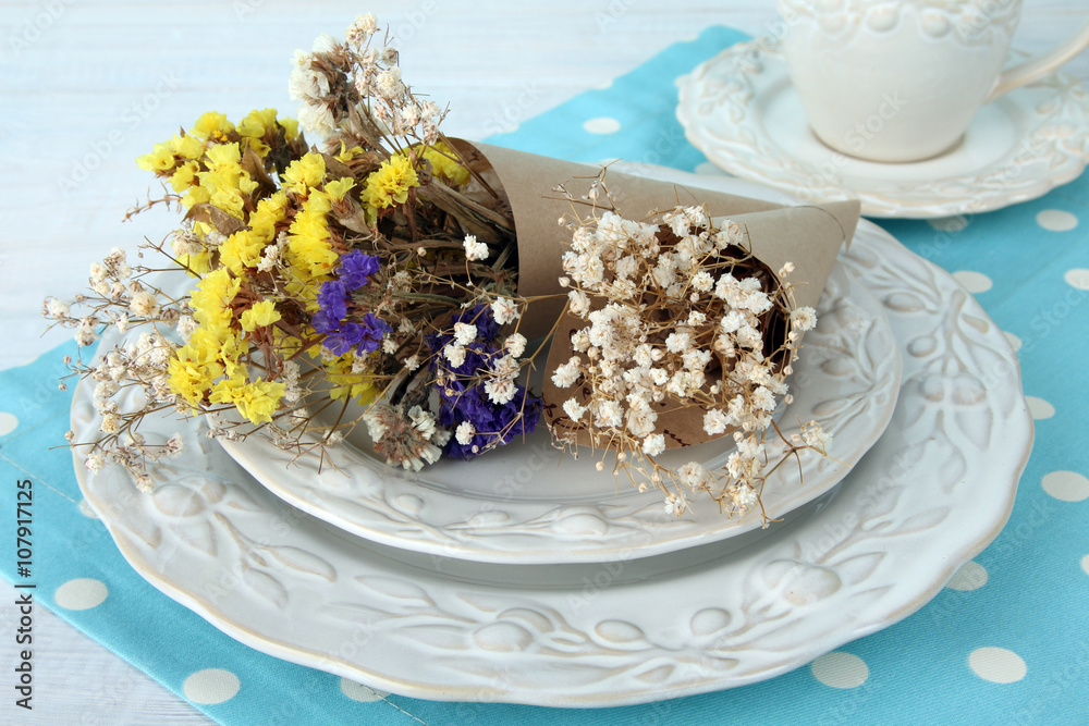 Fototapeta premium dried flowers on the plate near the Cup on wooden background