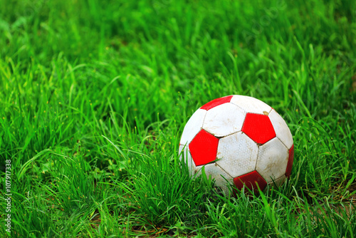 Old soccer ball in grass