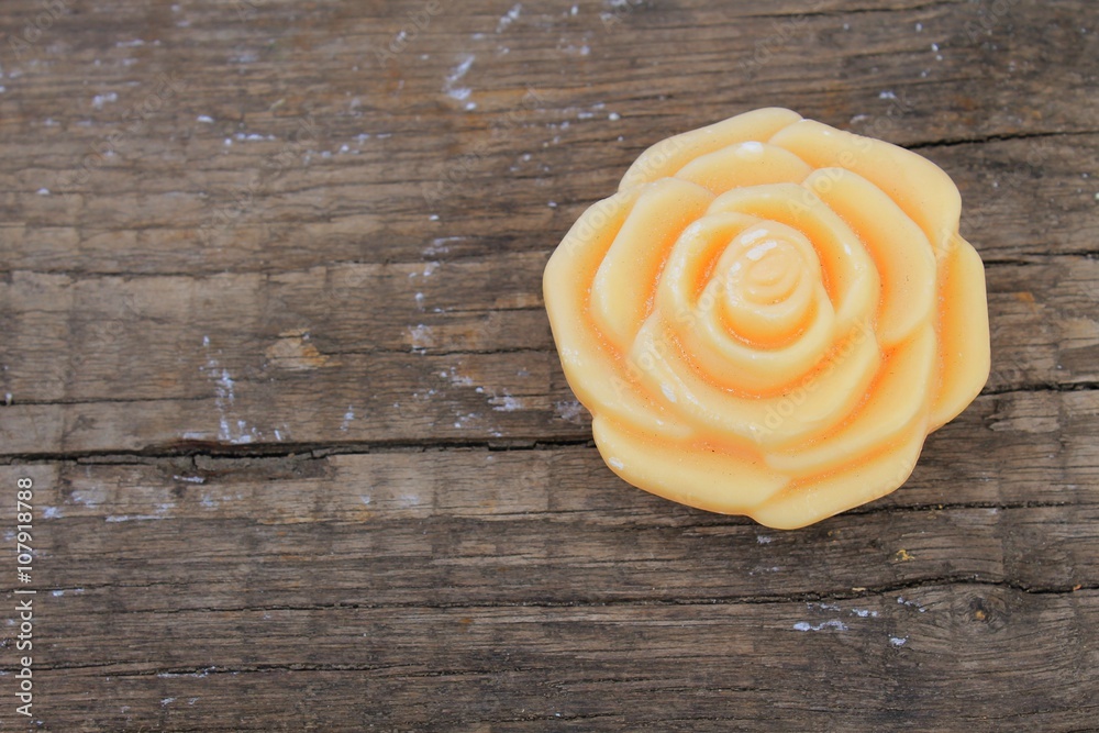 Soap in form a rose on wooden background 