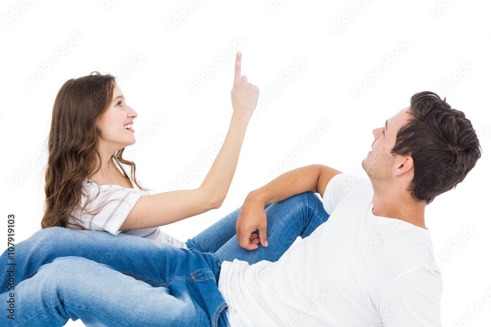 Happy couple lying on the floor pointing up Happy couple lying on the floor pointing up