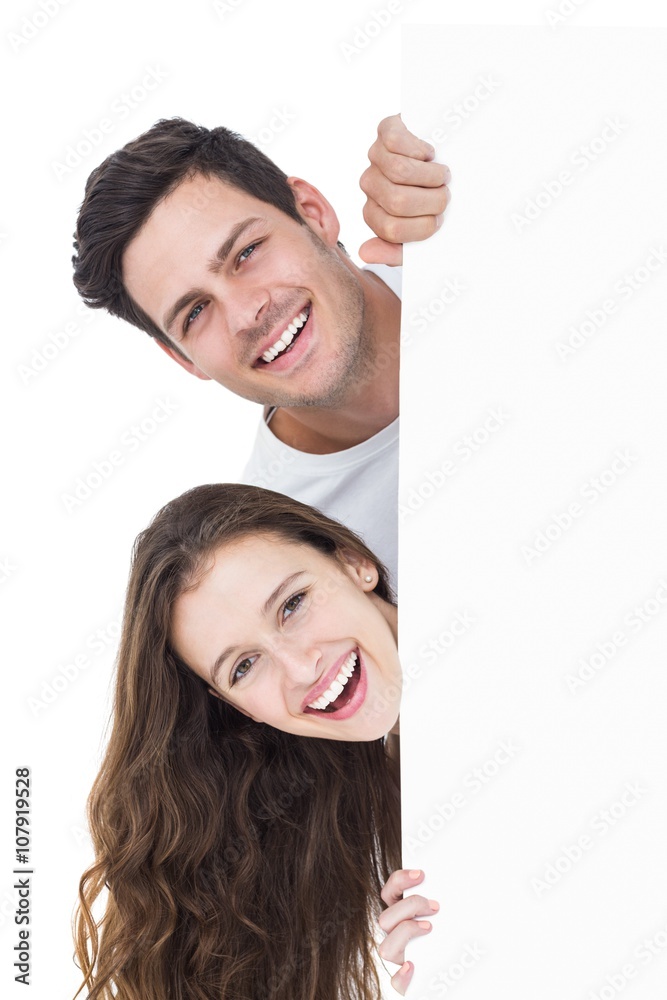 Happy couple looking over a poster Happy couple looking over a poster