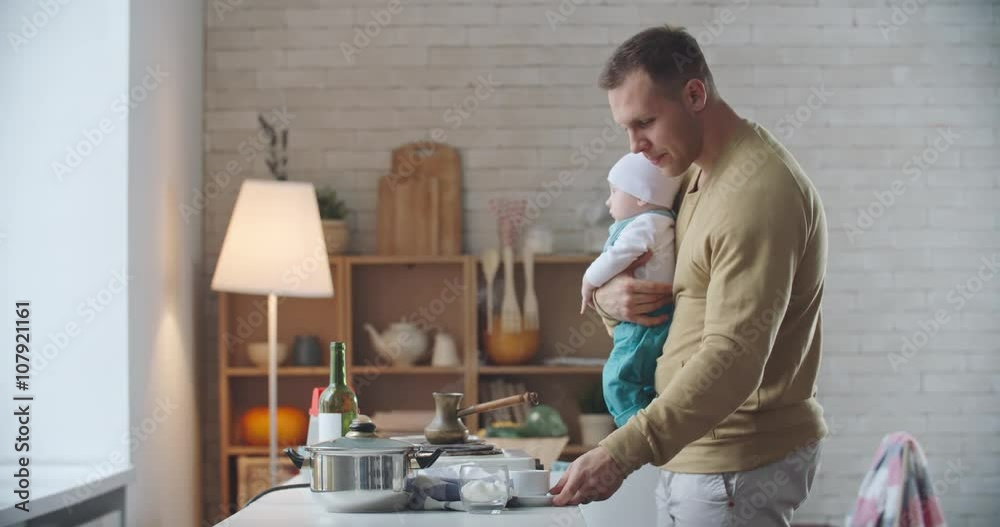 Father holding his adorable child, pouring freshly brewed coffee in cup and enjoying how it smells Father holding his adorable child, pouring freshly brewed coffee in cup and enjoying how it smells