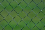 Maschendrahtzaun mit grünem Hintergrund