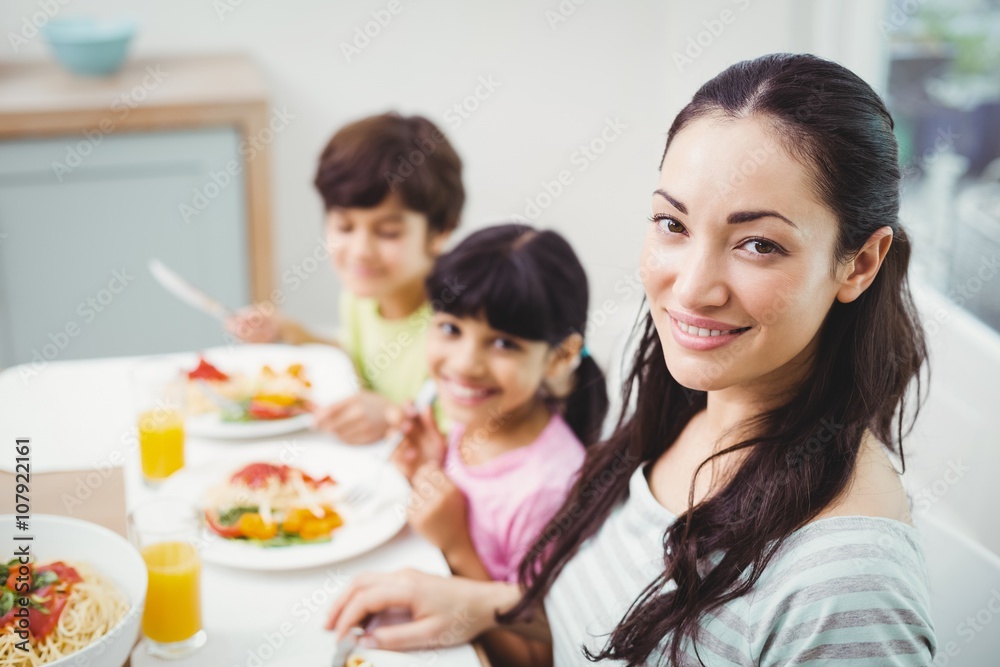 Portrait of smiling mother with children at dining table Portrait of smiling mother with children at dining table