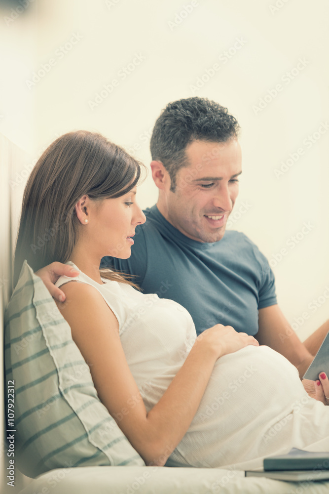 Pregnant brunette mum with husband read in bed Pregnant brunette mum with husband read in bed