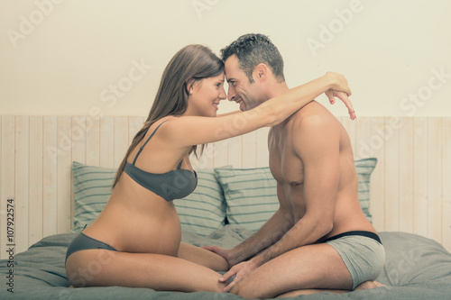 Billede på lærred Expecting pregnant couple make cuddle in bed