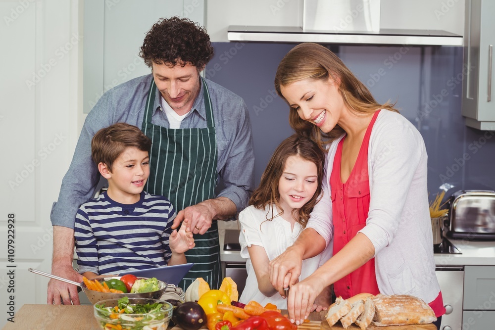 Happy parents with son and daughter in kitchen