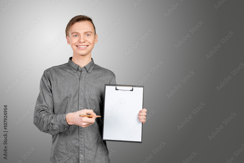 confident young man in shirt making notes in his pad confident young man in shirt making notes in his pad