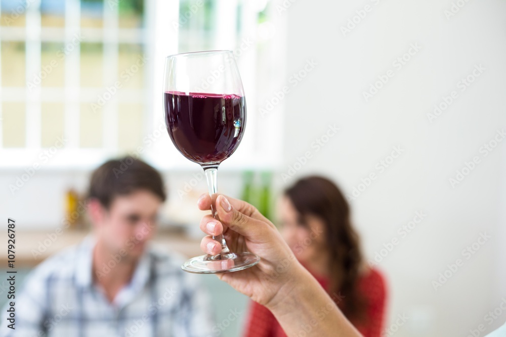 Cropped hand holding red wine glass 