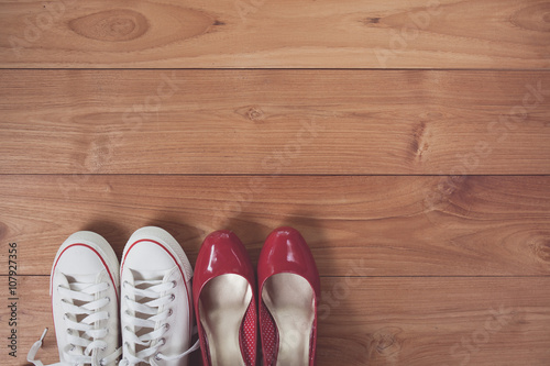 Vintage tone of couple shoes over wooden deck floor.