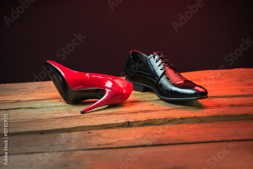 Red and black stylish shoes on the wood floor at night with red light
