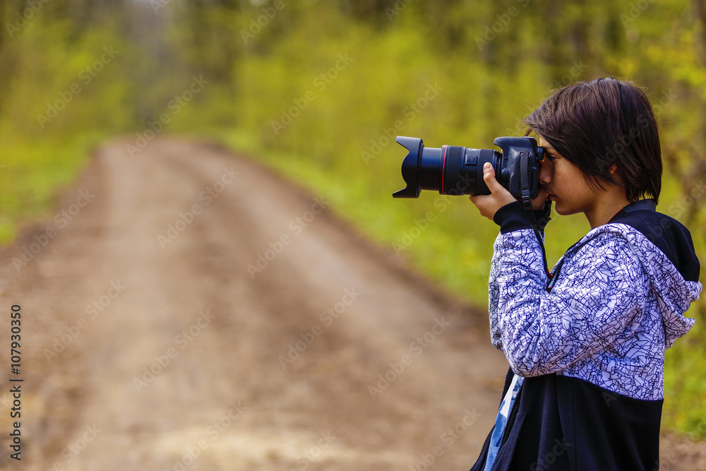 young photographer who takes pictures in forest