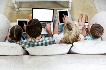Overhead view of family using various technologies