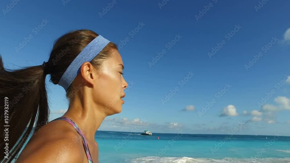 Runner girl jogging in summer on beach. Determined young woman running. Fit young female in sportswear is jogging by idyllic sea. Jogger is exercising on sunny day against blue sky. ACTION CAMERA. Runner girl jogging in summer on beach. Determined young woman running. Fit young female in sportswear is jogging by idyllic sea. Jogger is exercising on sunny day against blue sky. ACTION CAMERA.