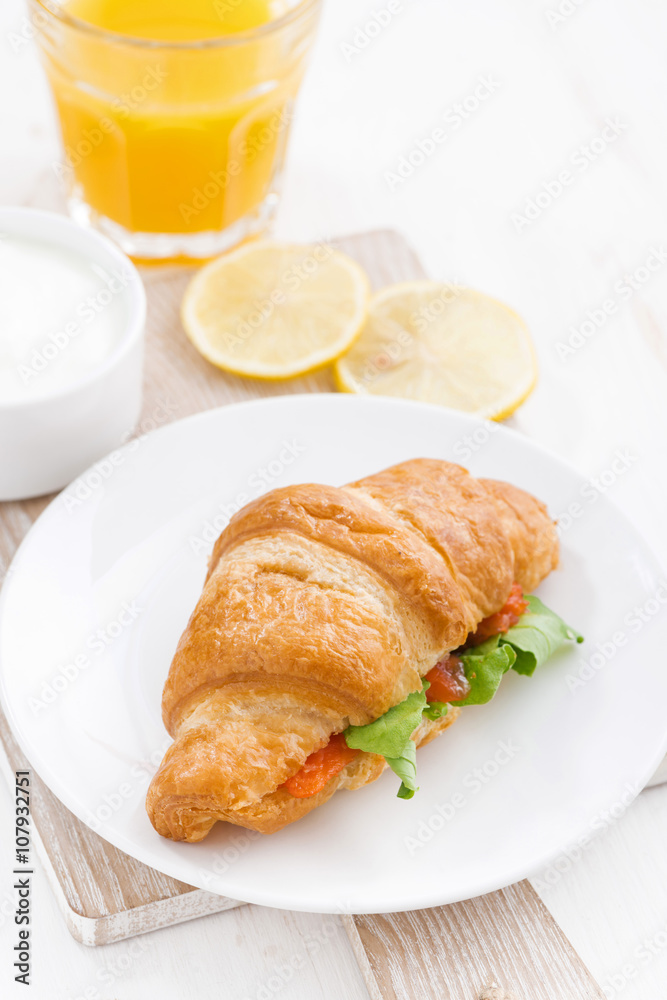 croissant with salted salmon and fresh arugula, top view