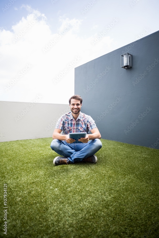 Man sitting on terrace holding digital tablet