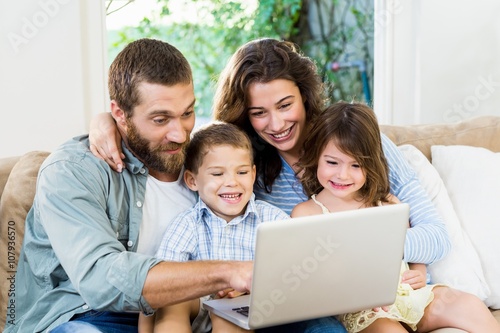 Smiling family with laptop