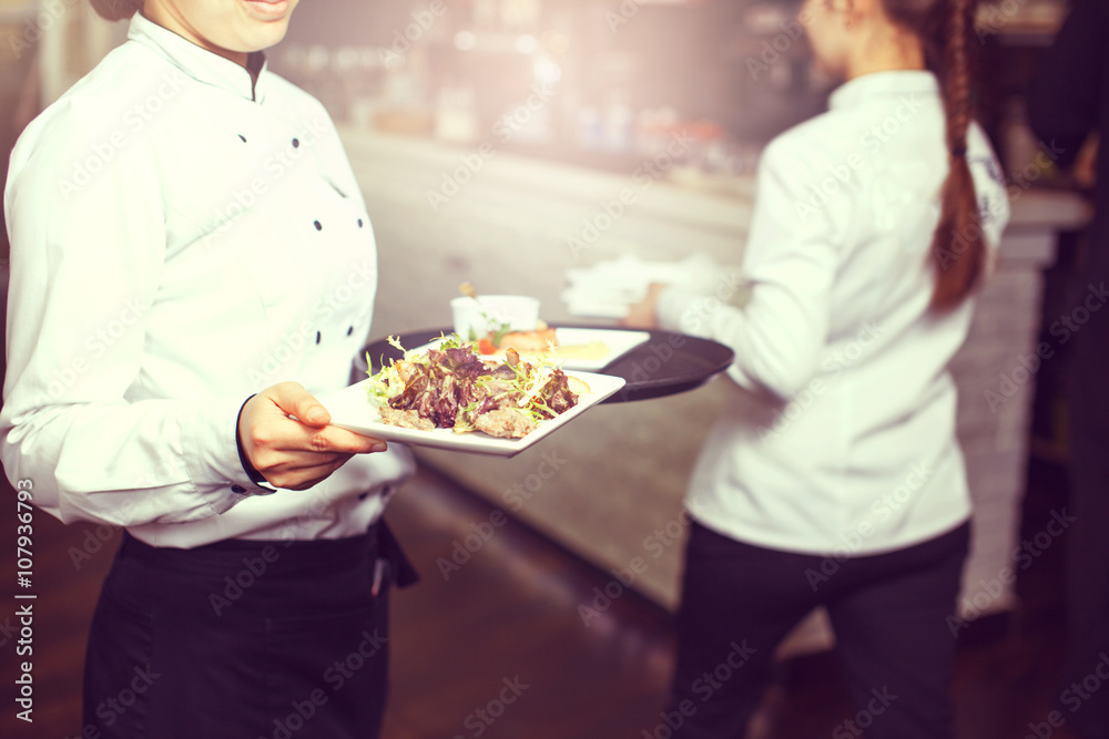 Waiters carrying plates with meat dish at a wedding. Waiters carrying plates with meat dish at a wedding.