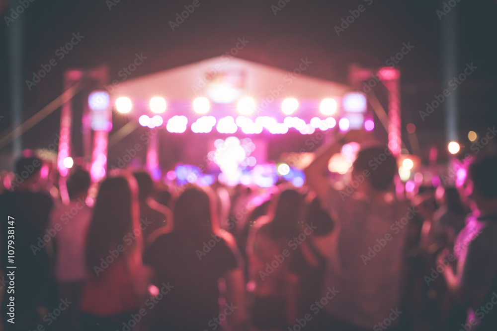 Crowd in front of concert stage with dancer blurred