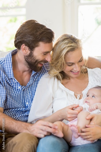 Parents sitting on sofa with their child