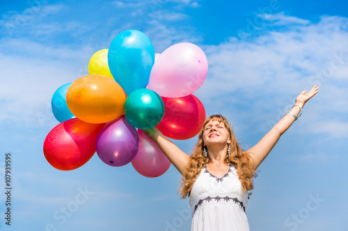 Happy young lady celebrates birthday with balloons