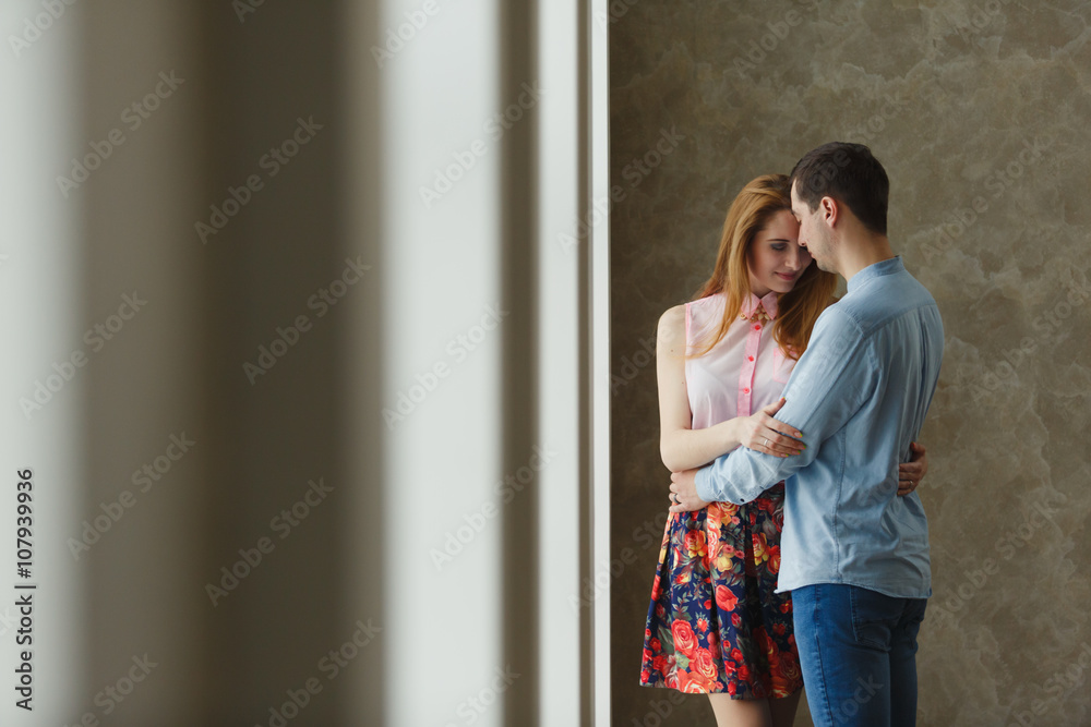 Naklejka premium man and woman near a large window.