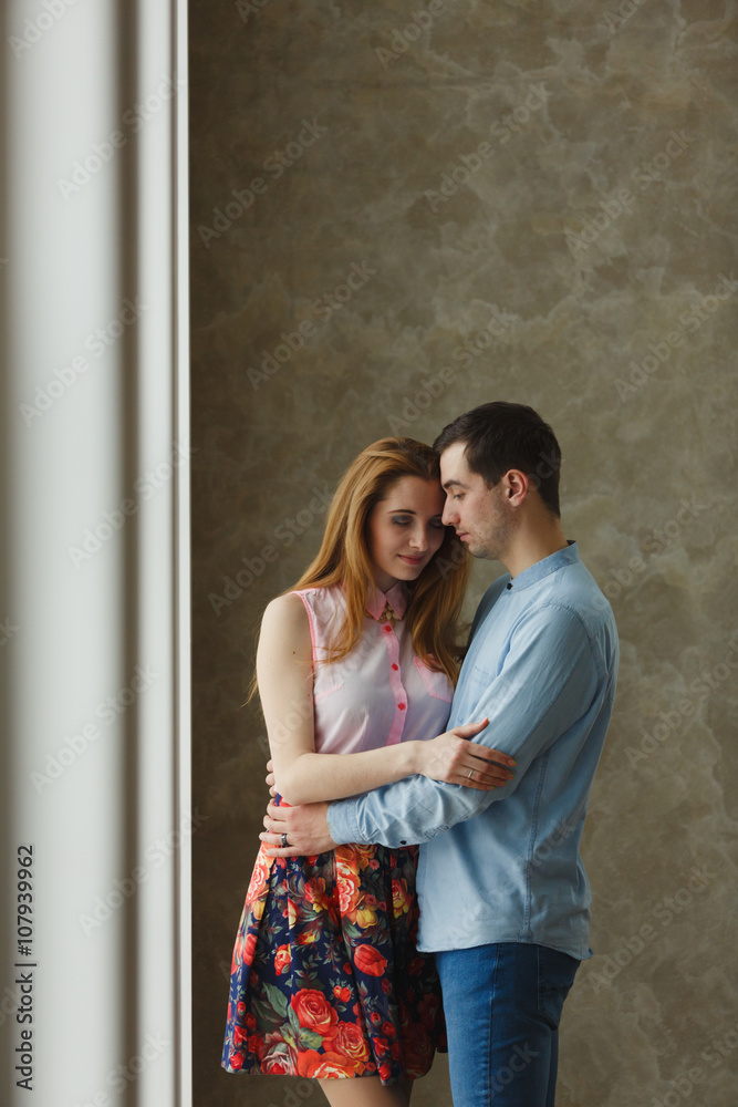 Naklejka premium man and woman near a large window.