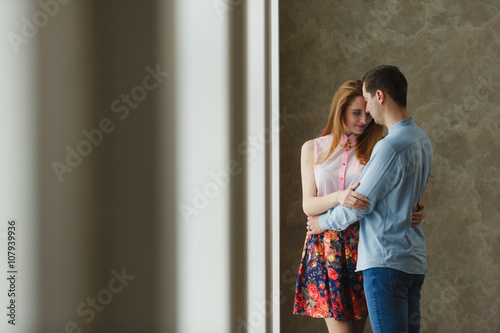 man and woman near a large window.