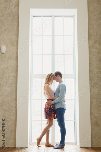 man and woman near a large window.
