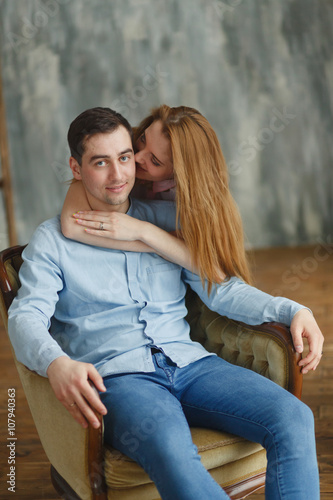 man and woman embracing in a chair new housing.