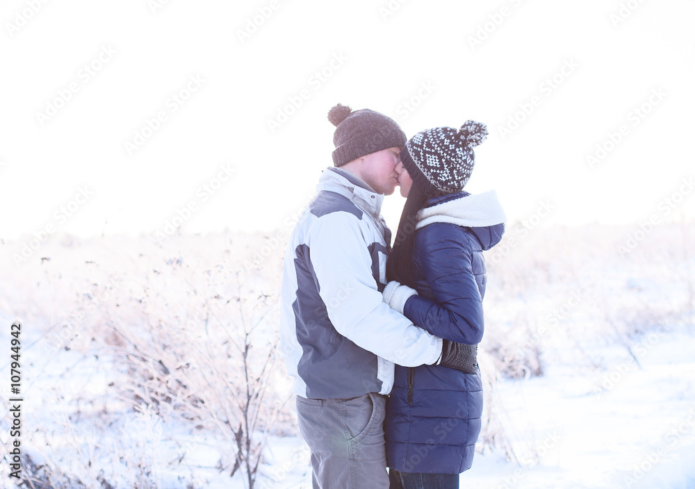 Young couple kissing in nature in winter